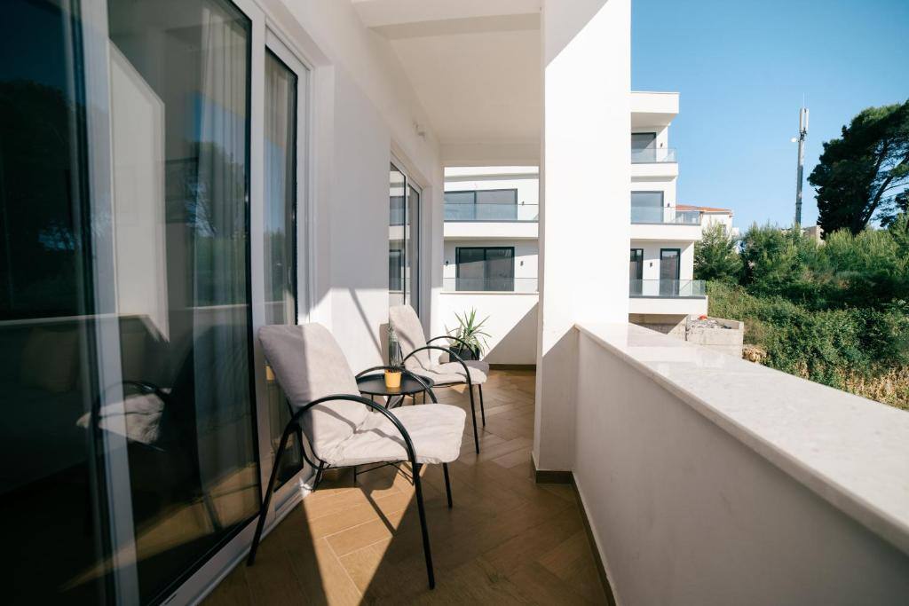 Balcony with two armchairs and a small table overlooking greenery in Ulcinj